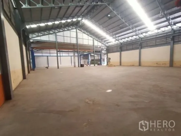 Factory for rent in Mueang Samut Sakhon, Samut Sakhon - Large open warehouse area with a gable roof, ventilation panels, and a polished concrete floor.