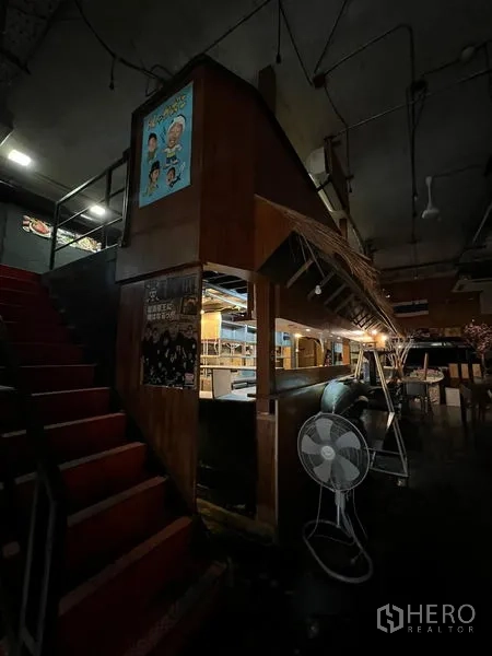 Retail Space for rent in Watthana, Bangkok - Dim restaurant interior with wooden service counter, staircase and industrial ceiling.