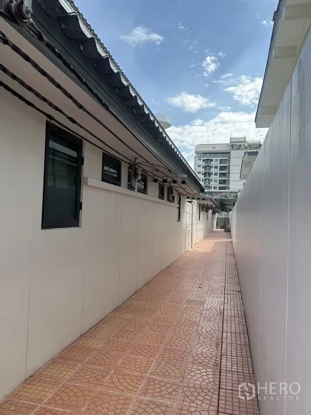 联排别墅 出租在Watthana, Bangkok - 房侧通道步行道，远处可见楼宇