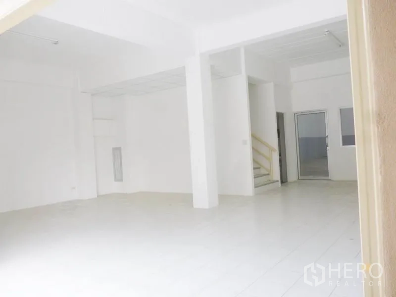 Factory for sale in Pathum Thani - Bright white office area with tiled floors, high ceiling and an internal staircase.