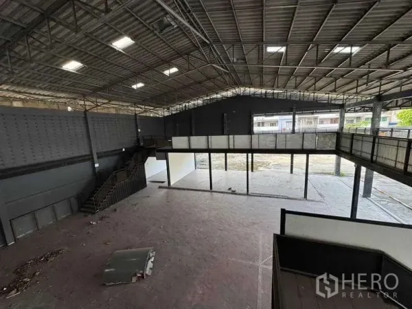 Warehouse for rent in Phra Khanong, Bangkok - Wide interior with clear span, staircases to the mezzanine and a concrete floor.