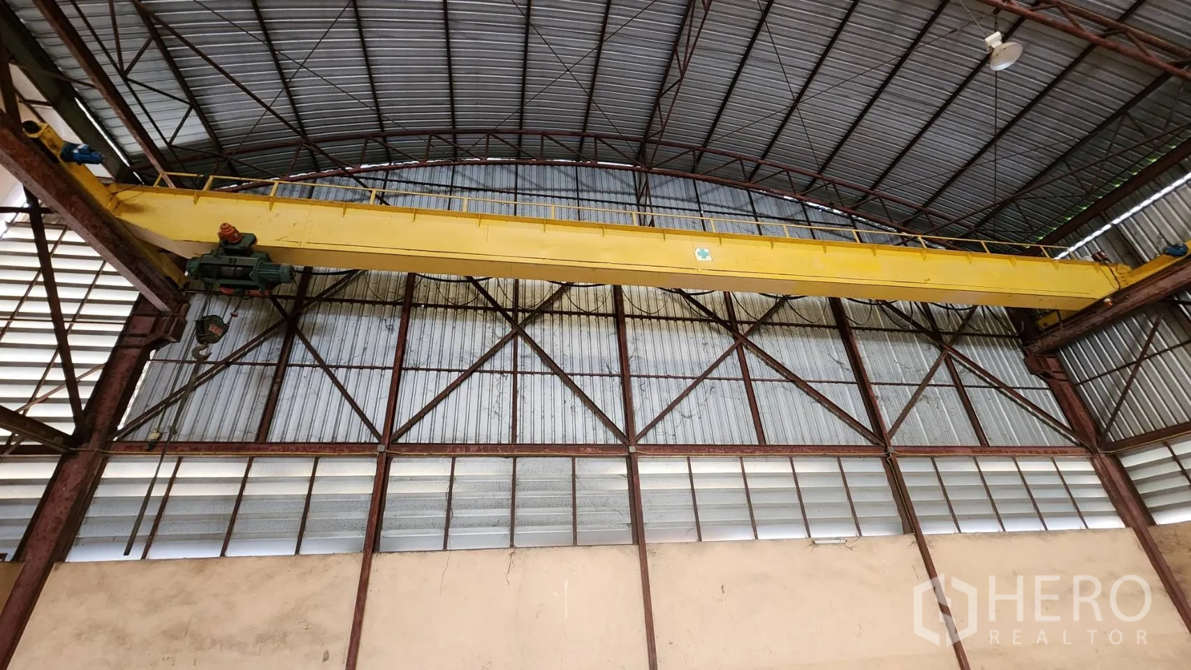 Warehouse for rent in Nonthaburi - Close-up of the 5-ton overhead bridge crane beneath a corrugated roof.