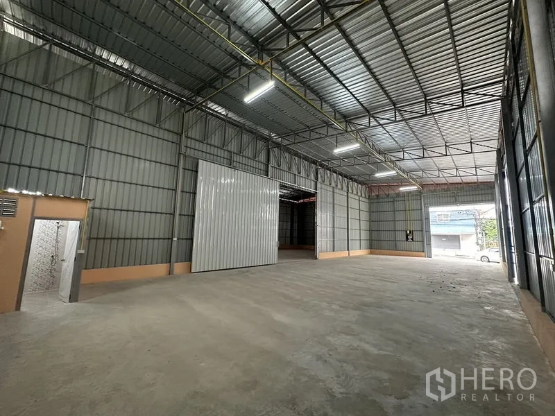 Warehouse for rent in Bueng Kum, Bangkok - Bright warehouse space with large front rolling door and ample loading area to the street.