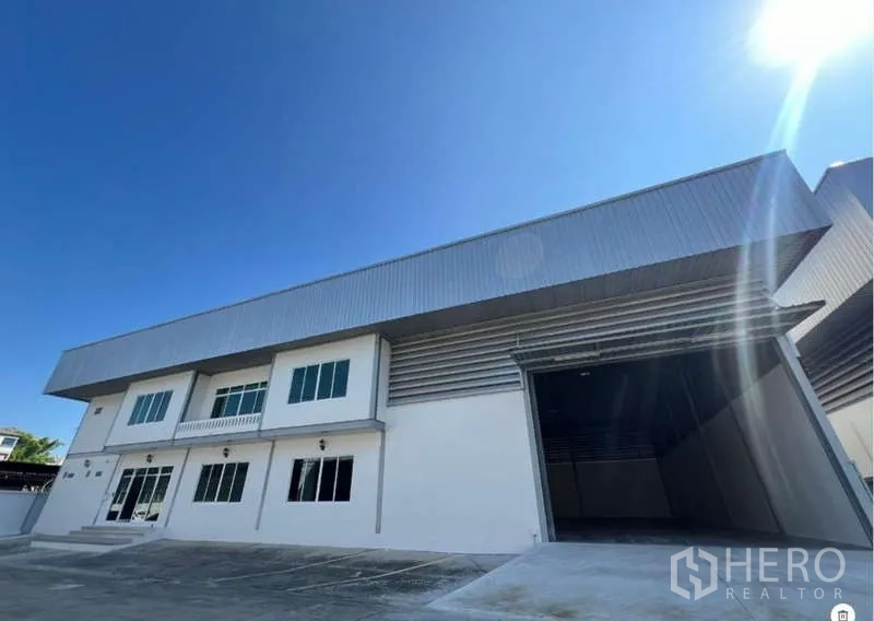 Warehouse for rent in Prawet, Bangkok - Warehouse exterior with wide roller shutter loading bay and paved parking apron.