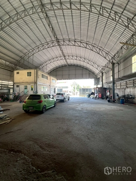 Factory for rent in Phra Pradaeng, Samut Prakan - Spacious factory floor with high arched steel roof and internal two‑storey office block.