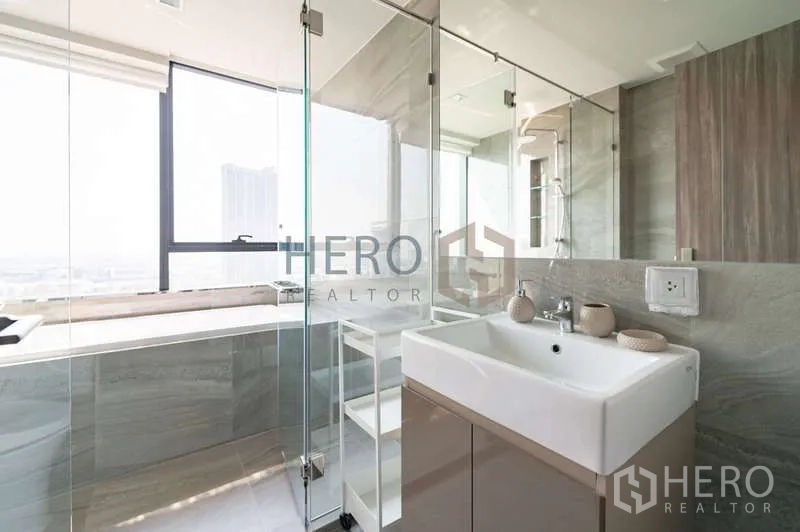 Condominium for rent - Bathroom with vanity, glass shower and windowed bathtub bringing in natural light.