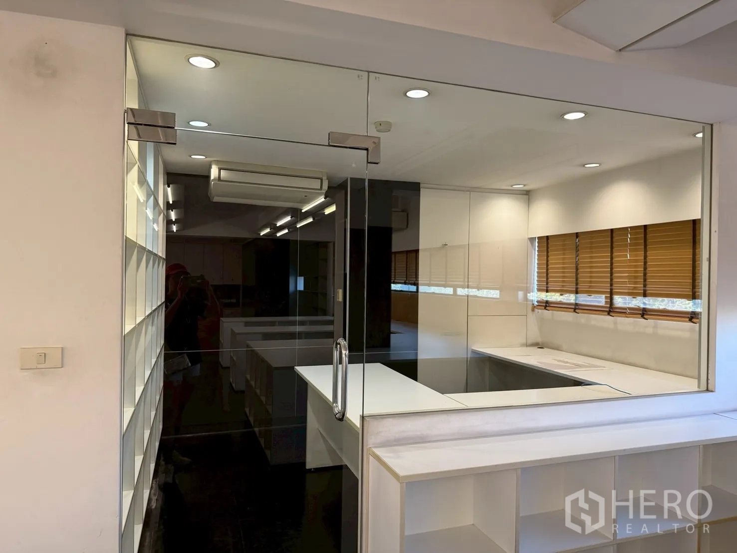Office Space for rent in Huai Khwang, Bangkok - View through a glass partition to clean desks and windows with blinds in an open office.
