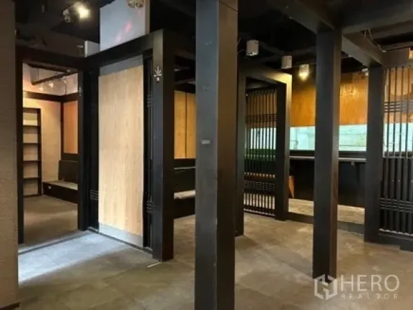 Retail Space for rent in Bang Rak, Bangkok - Open-plan retail interior with black columns, wood slat partitions, track lighting and tiled flooring.
