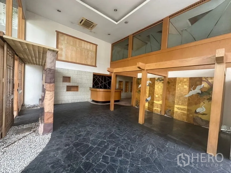Retail Space for rent in Bang Rak, Bangkok - Main hall with mezzanine, reception counter, wood framing, and stone flooring.