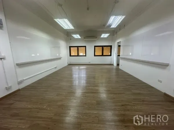 Office Space for rent in Chatuchak, Bangkok - Open-plan office with wood floors, white walls, LED panel lights, three windows and air-conditioning.