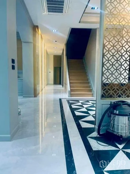 Detached House for sale in Mueang Nonthaburi, Nonthaburi - Bright corridor with staircase, decorative screen panels and polished marble flooring.