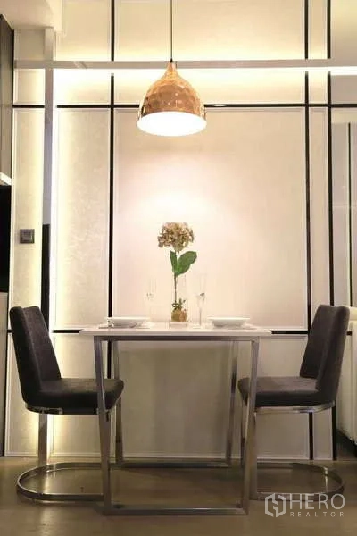 Condominium for rent in Watthana, Bangkok - Dining nook for two under brass pendant lamp with minimalist decor.
