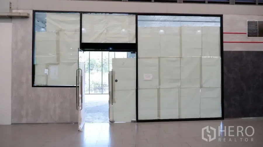 Retail Space for rent in Watthana, Bangkok - Glass storefront with framed door opening from an interior corridor, windows covered during fit-out.