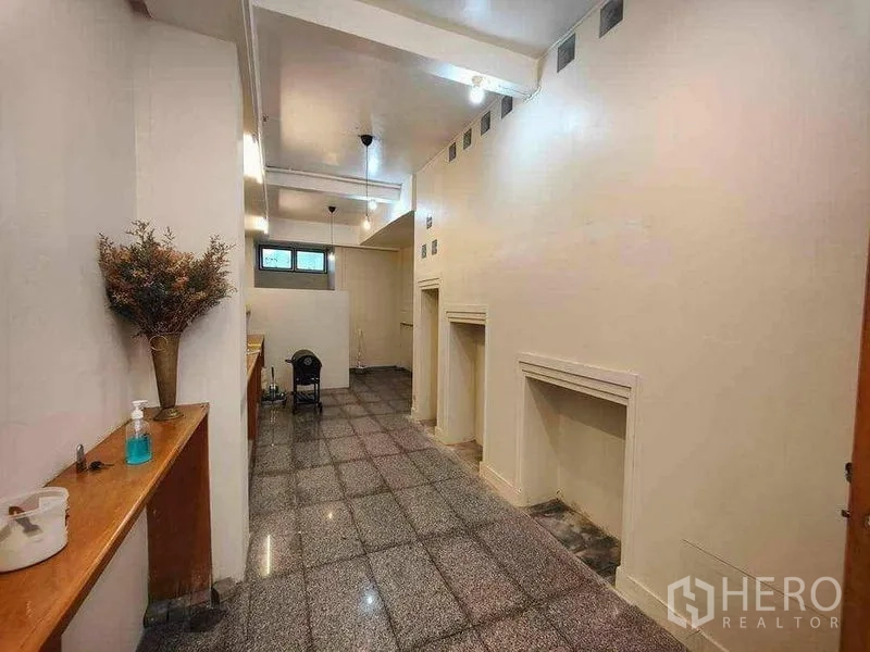 Retail Space for rent in Khlong Toei, Bangkok - High-ceiling retail hall with recessed wall niches, display lighting and a small rear window.