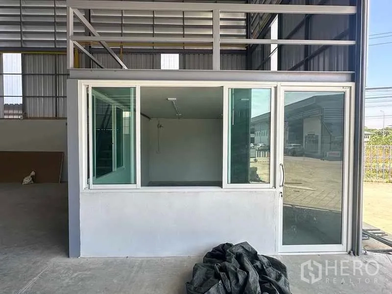 Warehouse for rent in Bang Bua Thong, Nonthaburi - Glass-front internal office box with sliding doors inside the warehouse.