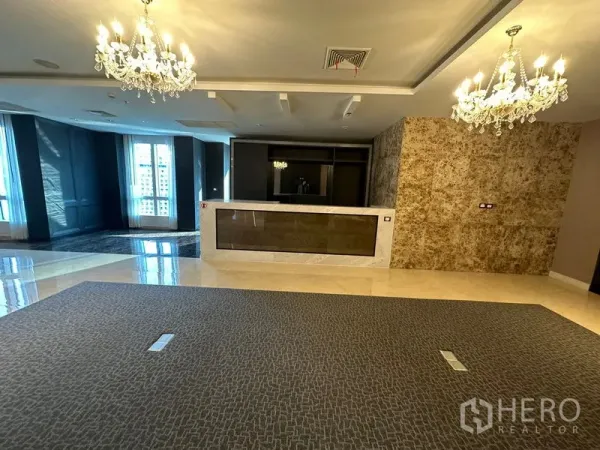 Office Space for rent - Reception area with marble counter, chandeliers, stone accent wall and large windows.