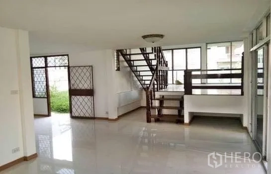 Home Office for rent in Chatuchak, Bangkok - Open-plan ground floor with large windows and wooden stairs facing the garden.