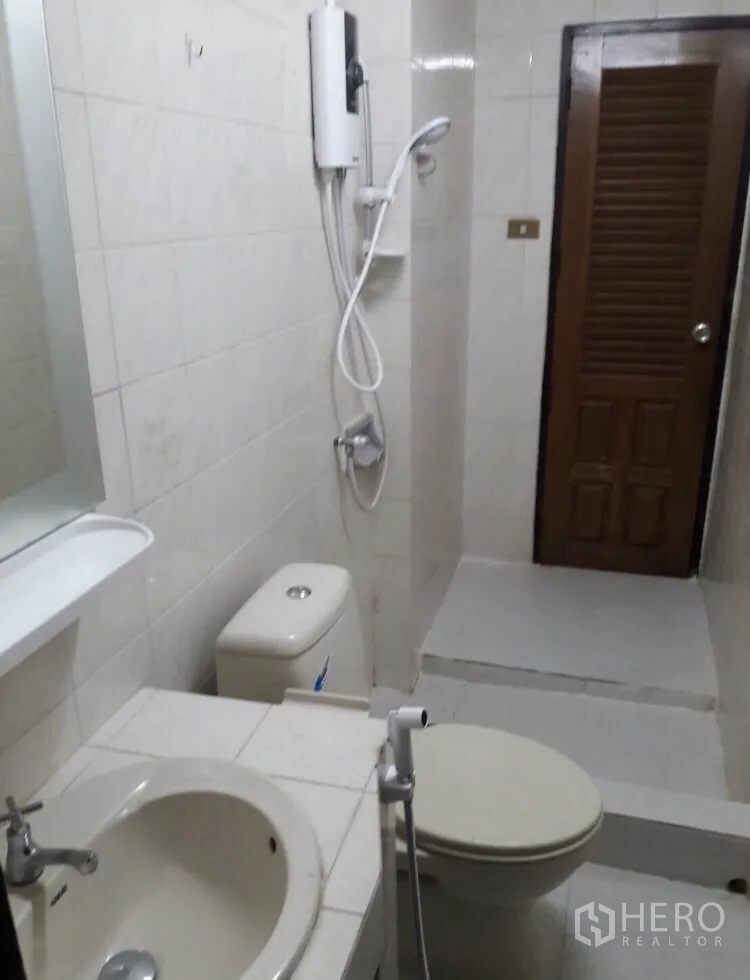 Townhouse for rent in Watthana, Bangkok - Bathroom with sink, toilet, handheld bidet and shower fitted with water heater.