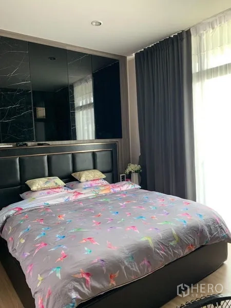 Townhouse for rent in Suan Luang, Bangkok - Bright master bedroom with upholstered headboard, floor-to-ceiling window and blackout curtains.