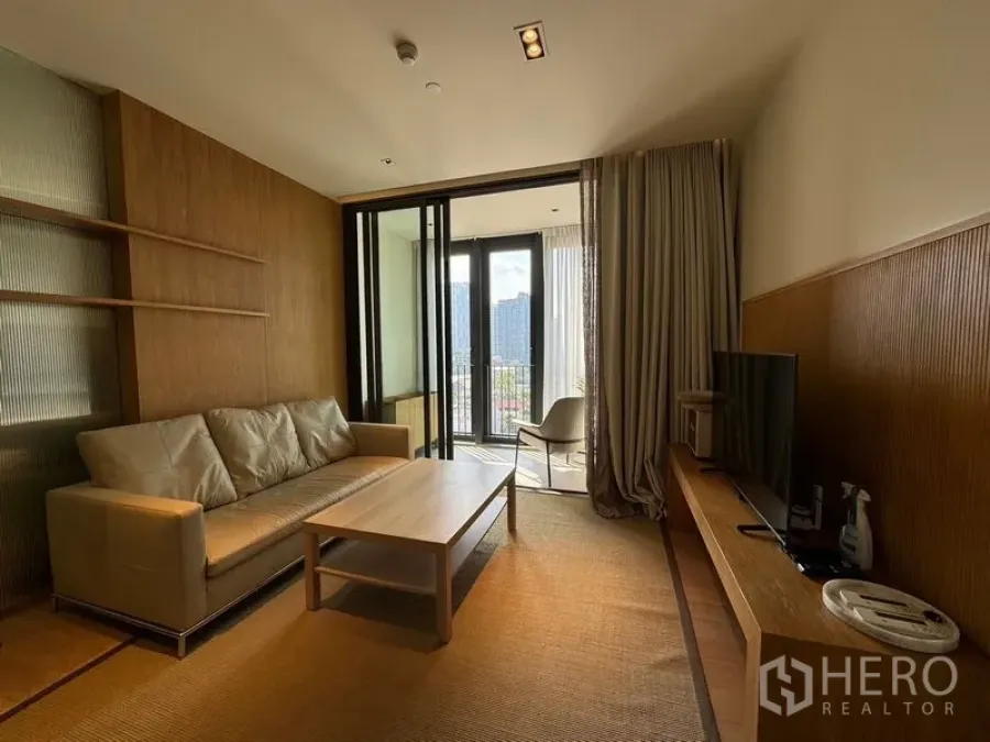 Condominium for rent - Living room opening to a balcony through floor-to-ceiling doors and neutral décor.