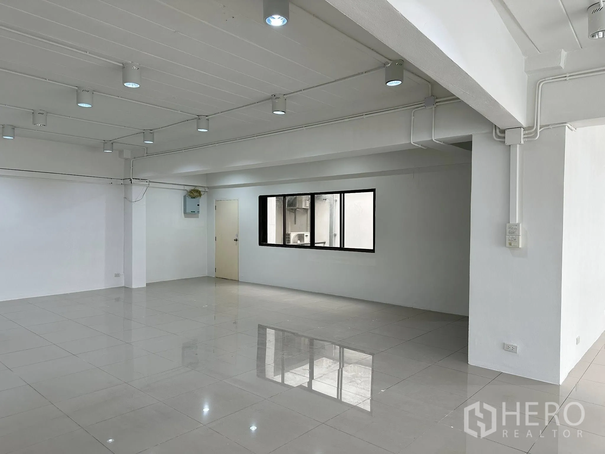 Office Space for rent in Watthana, Bangkok - Spacious interior showing window, door and electrical panel in a clean open layout.