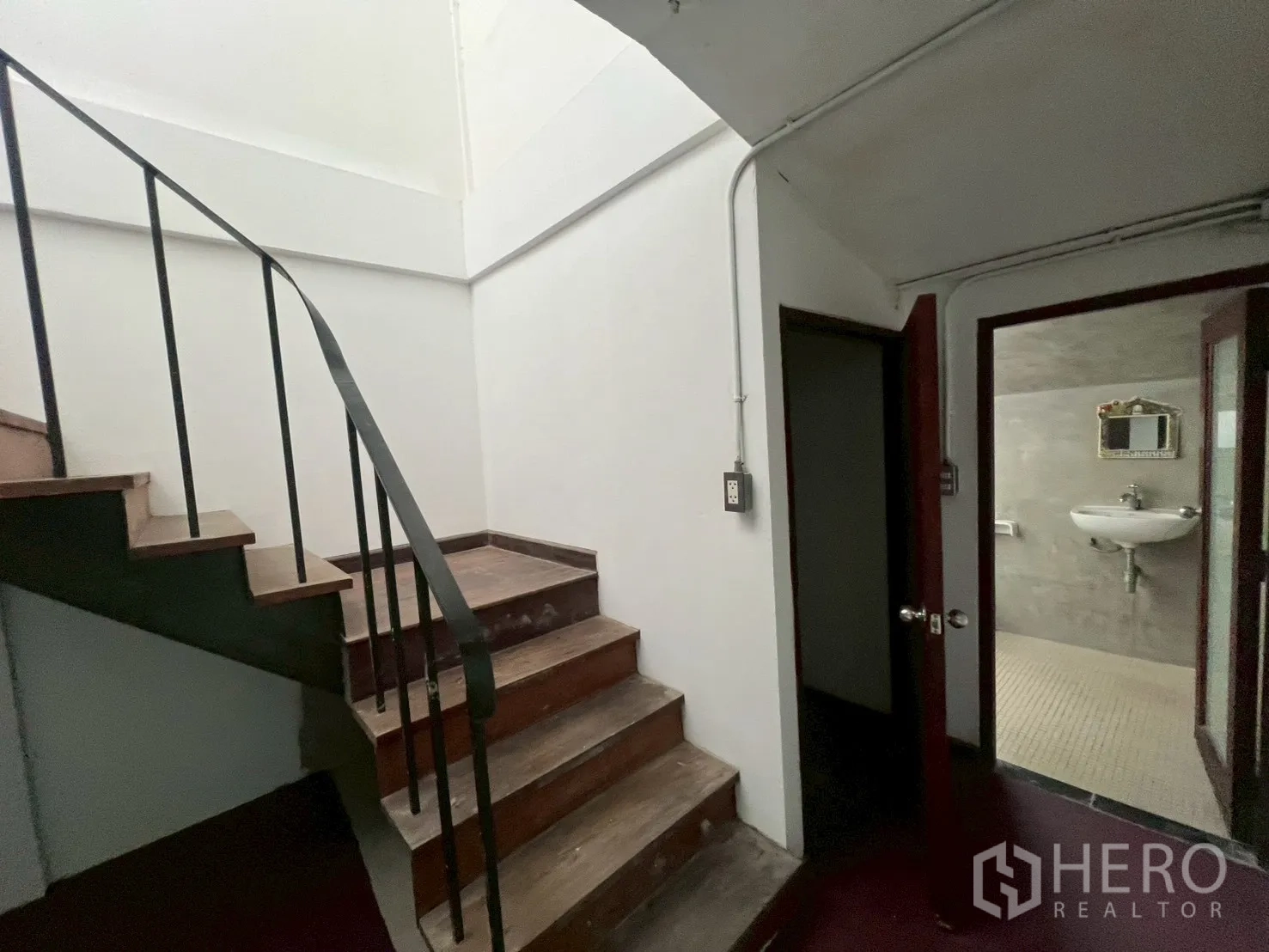 โฮมออฟฟิศ for rent in Watthana, Bangkok - โถงบันไดมีประตูเข้าสู่ห้องน้ำและพื้นที่ใช้งาน พร้อมอ่างล้างหน้าติดผนัง