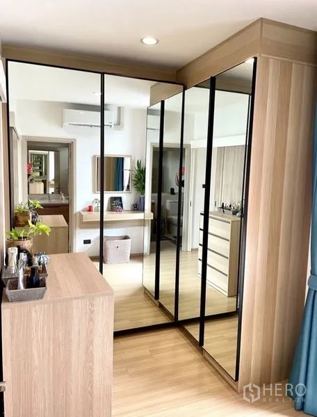 Townhouse for rent in Suan Luang, Bangkok - Walk-in closet with mirrored sliding doors and light wood cabinetry.