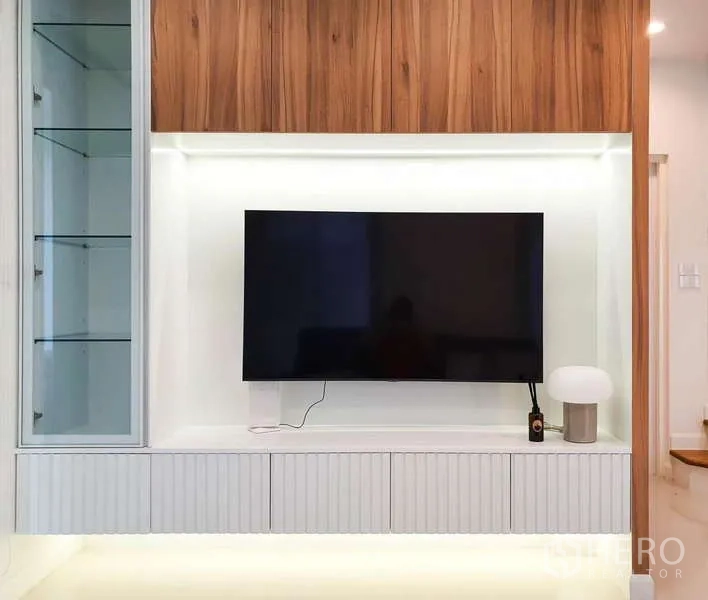 Detached House for rent in Sathon, Bangkok - Built-in media wall with mounted TV, display cabinet, and wood accents.