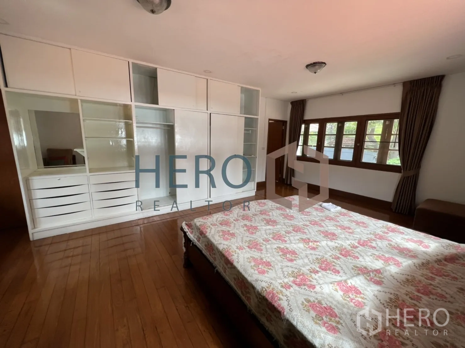 Detached House for rent in Watthana, Bangkok - Bedroom with large white built-in closets and windows.