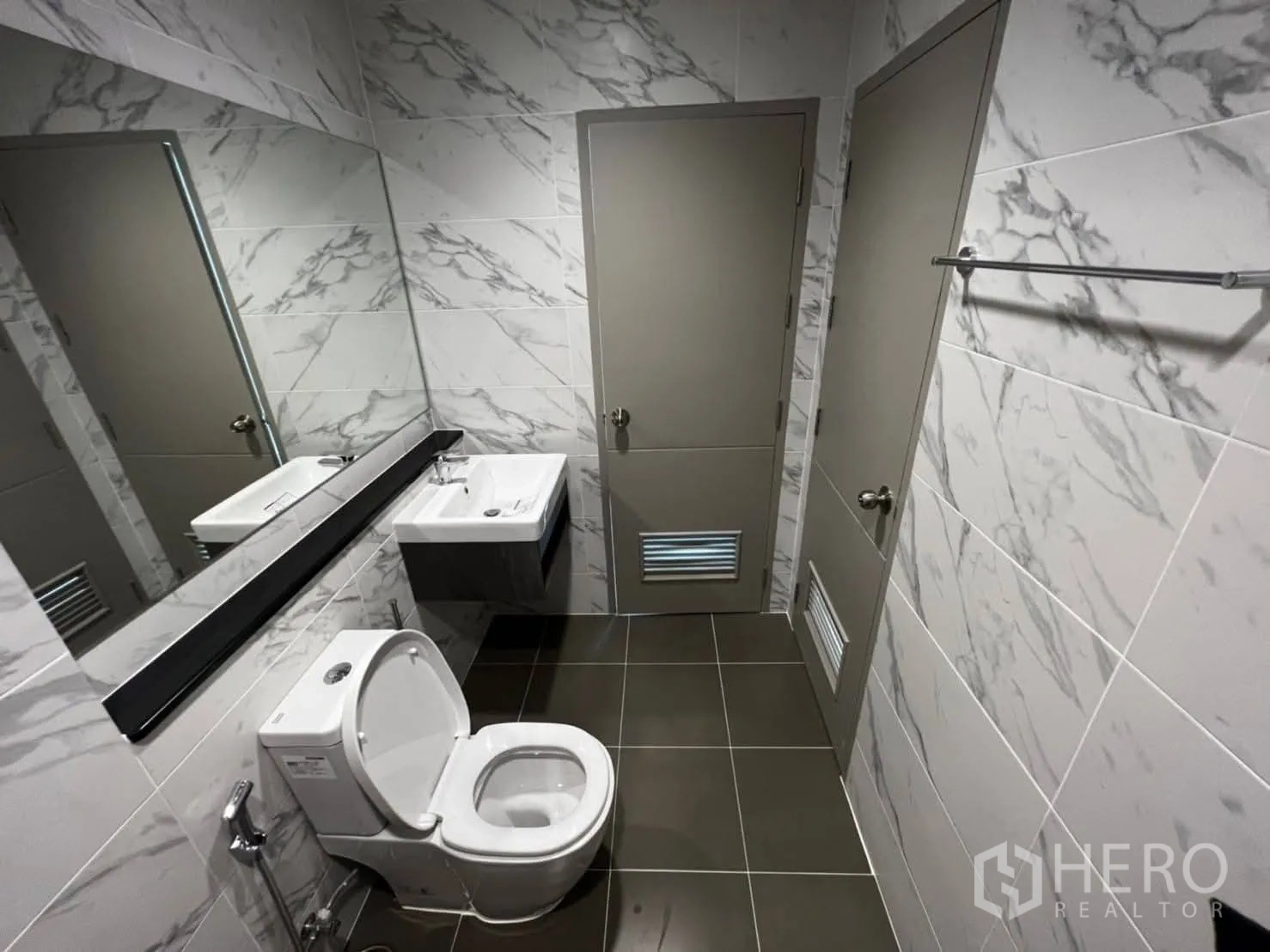 Townhouse for rent in Bang Khen, Bangkok - Shower bathroom with chevron accent wall, marble tiles, and white sanitary ware.