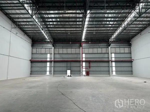 Warehouse for rent in Bang Phli, Samut Prakan - Spacious warehouse interior with high steel truss roof and skylight strips.