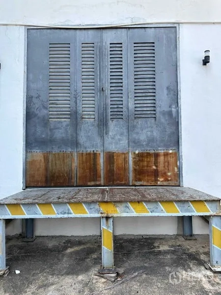 Warehouse for rent in Phra Khanong, Bangkok - Raised loading dock with metal double doors suitable for truck access.