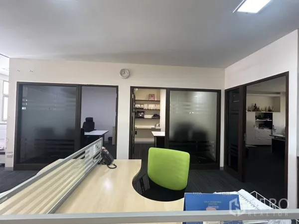 Office Space for rent - Glass-partitioned private offices and meeting rooms adjacent to the main workspace.
