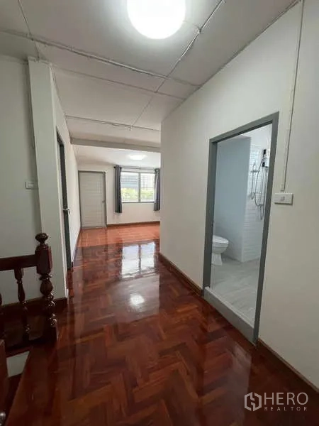 Detached House for rent in Bang Na, Bangkok - Hallway leading to a bright bedroom and bathroom on the upper floor.