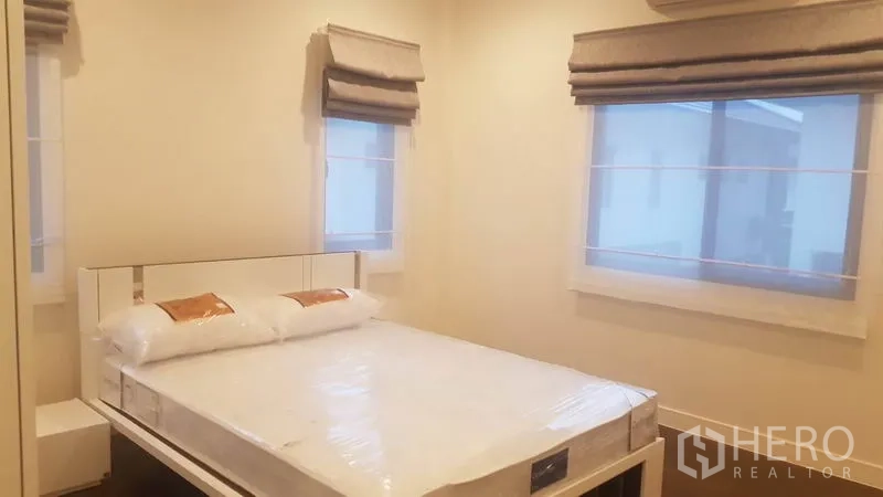 Detached House for rent in Saphan Sung, Bangkok - Cozy bedroom with queen bed, two windows and fabric Roman blinds.