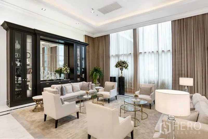 Condominium for rent in Pathum Wan, Bangkok - Elegant residents’ lounge with high ceilings, neutral sofas, glass display cabinet and full‑height curtains in a luxury Bangkok condominium.
