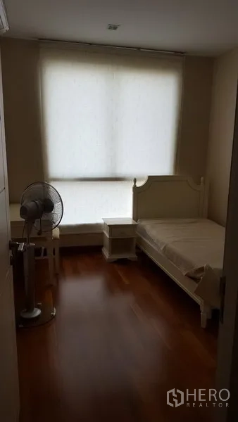 Condominium for rent in Bang Rak, Bangkok - Second bedroom with single bed, nightstand and large shaded window on wooden floor.