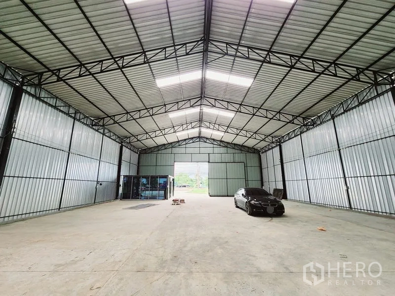 Warehouse for rent in Sam Phran, Nakhon Pathom - Deep view of the open warehouse floor under a high gabled roof with steel trusses.