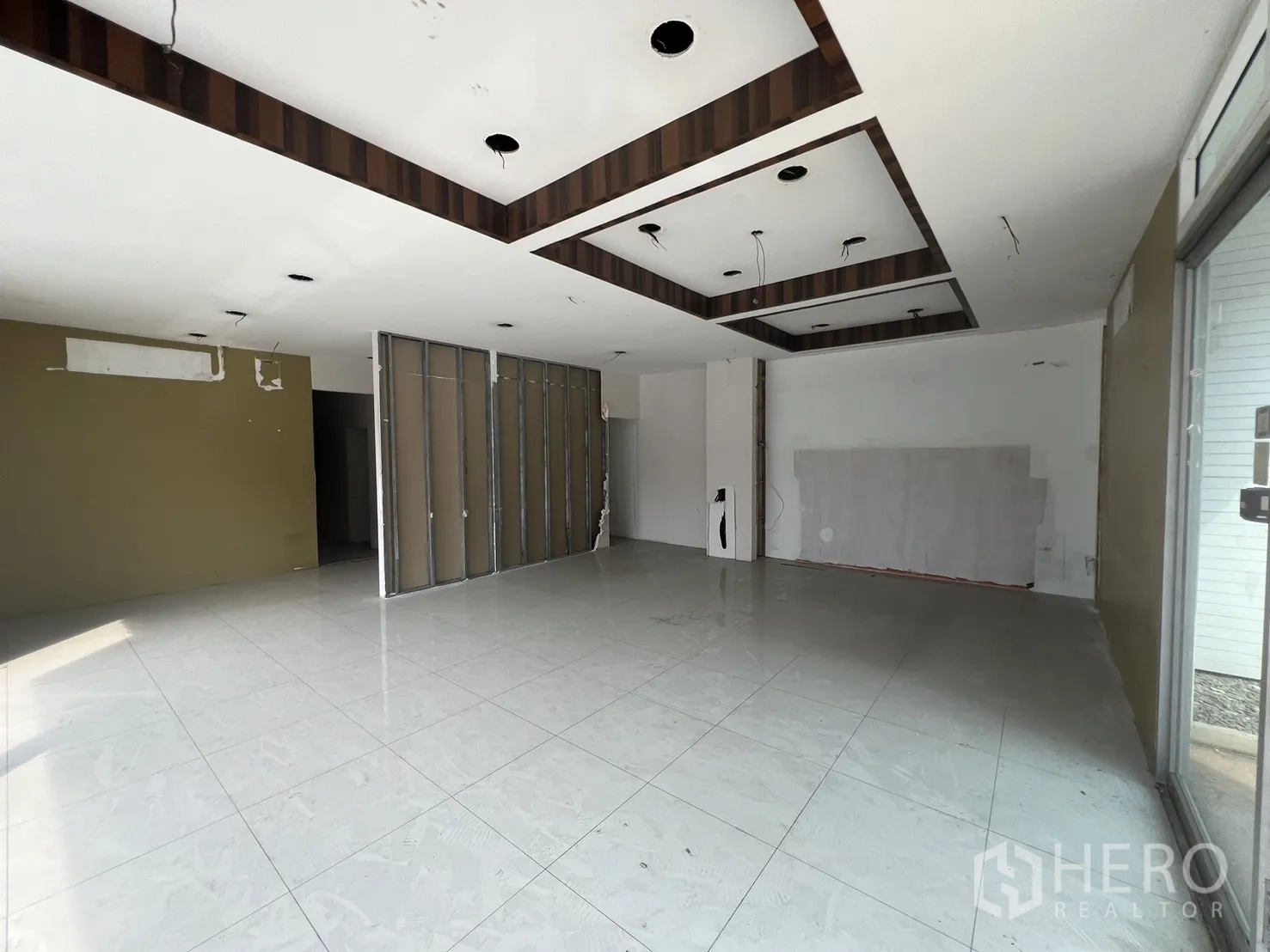 Retail Space for rent in Khlong Toei, Bangkok - Large open showroom with feature ceiling panels and floor-to-ceiling windows.