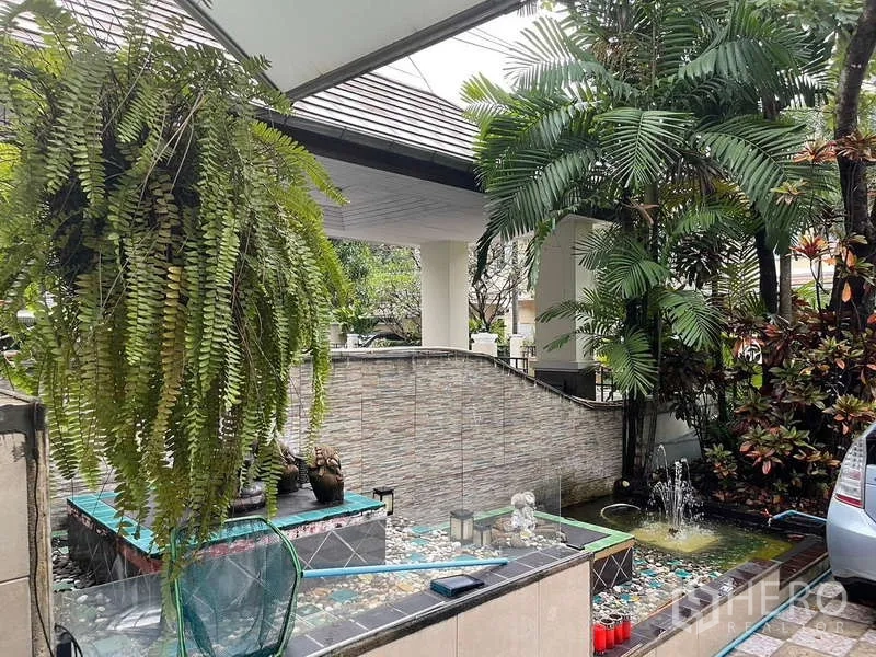 Detached House for sale in Suan Luang, Bangkok - Covered carport with decorative water feature and hanging ferns.
