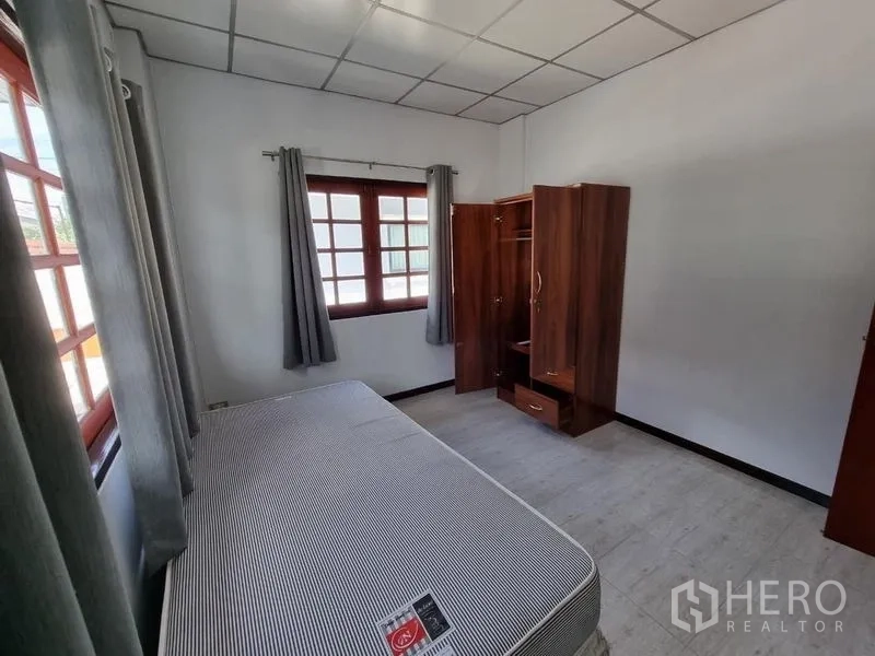 Detached House for rent in Nonthaburi - Cozy bedroom with a single bed, wardrobe, and two windows.