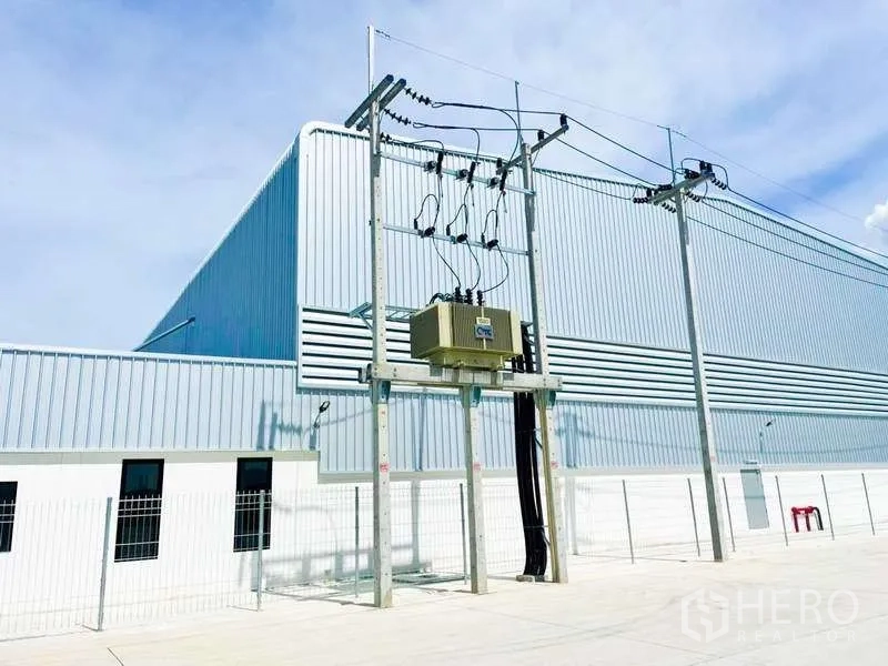 货栈 出租在Mueang Rayong, Rayong - 仓库外立面旁的工业变压器与三相供电架空线