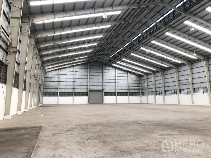 Warehouse for rent in Phra Nakhon Si Ayutthaya - Vast warehouse interior with high steel truss roof, skylights, and open clear span.