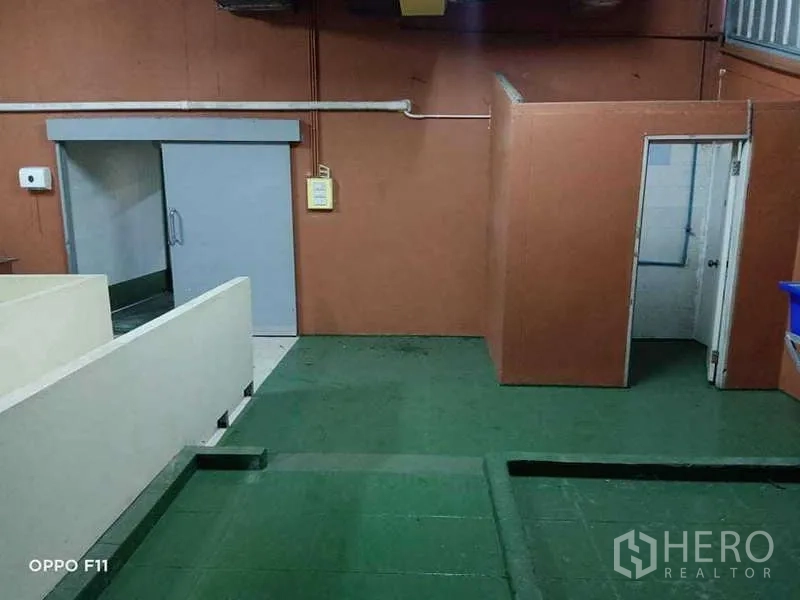 Warehouse for rent or sale in Mueang Samut Sakhon, Samut Sakhon - Processing zone with green epoxy floor, insulated walls, and sliding cold-room door.