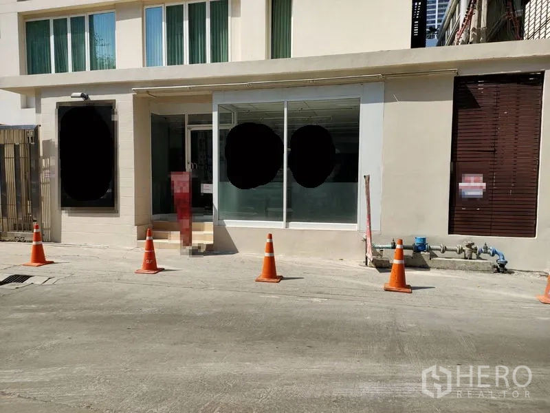 Retail Space for rent in Khlong Toei, Bangkok - Street-facing ground-floor retail frontage with large glass windows, entry steps and traffic cones in Khlong Toei, Bangkok.