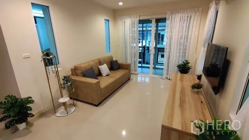 Detached House for rent in Bang Phli, Samut Prakan - Cozy lounge with sofa, TV console and sliding glass doors to the patio.