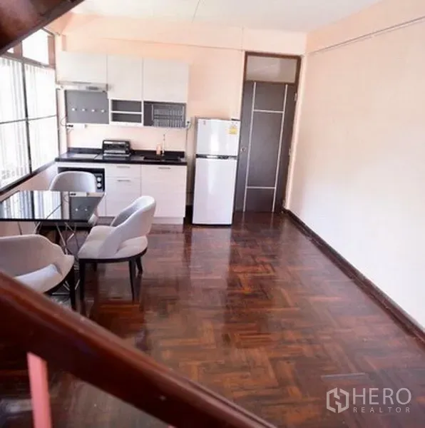 Detached House for rent in Bang Na, Bangkok - Open-plan kitchen and dining space with parquet floors, large windows and a fridge.