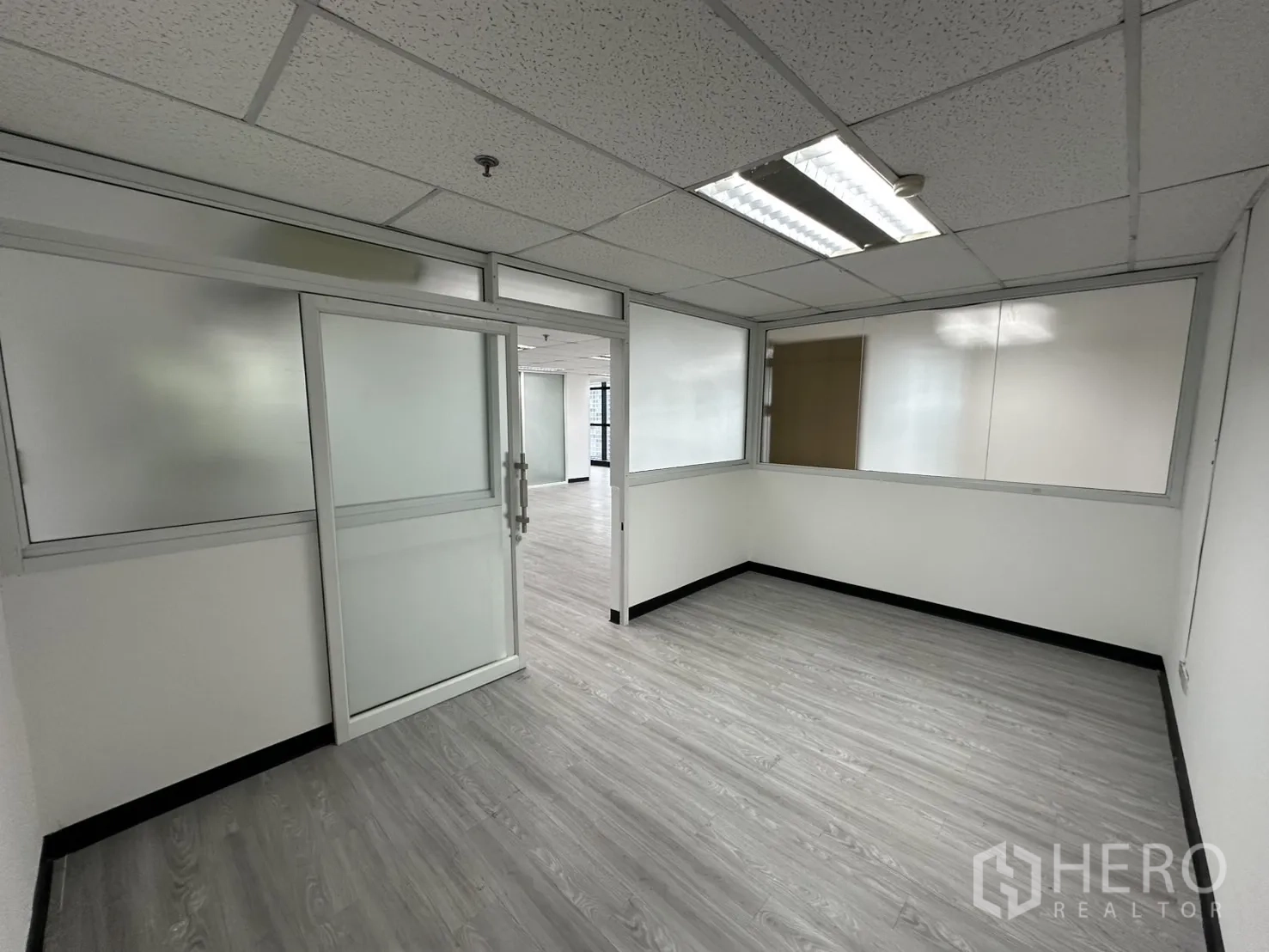 Office Space for rent in Watthana, Bangkok - Enclosed meeting room with frosted-glass partitions, sliding door and grey vinyl flooring.