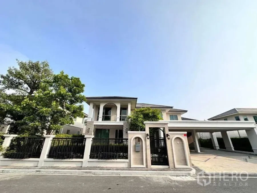 บ้าน ให้เช่าหรือขายในLat Krabang, Bangkok - มุมมองด้านหน้าบ้านพร้อมประตูรั้วนิรภัยและที่จอดรถคลุมหลังคา