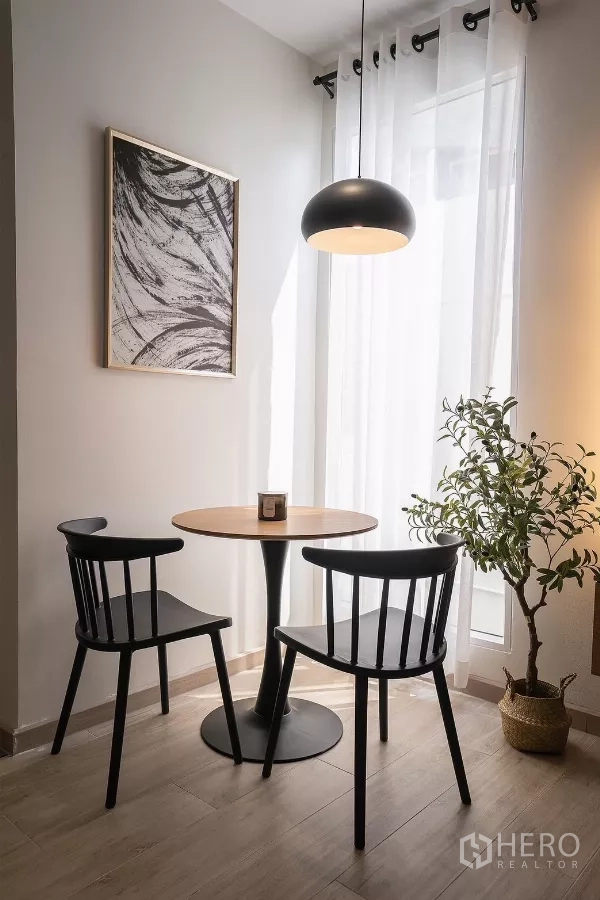 Detached House for rent in Huai Khwang, Bangkok - Sunlit breakfast nook with round table, two black chairs and pendant light.